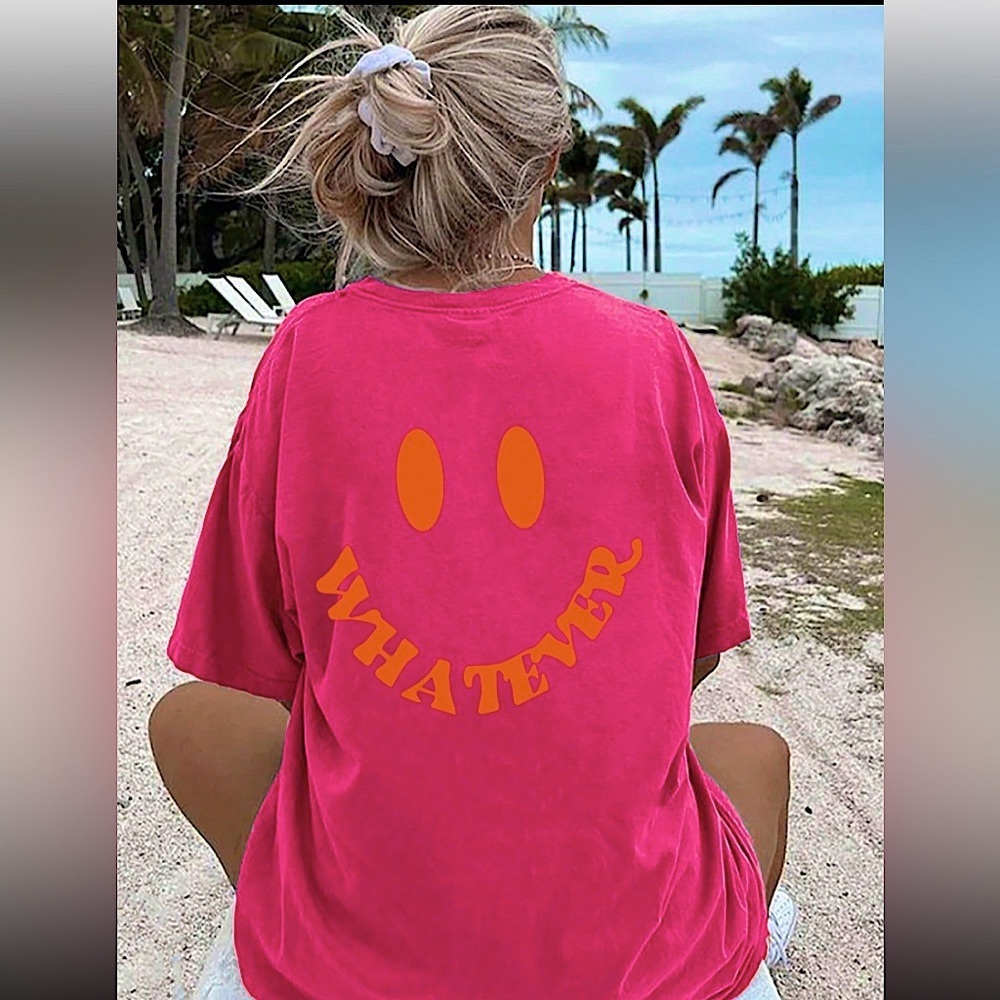 Vibrant hot pink tee with an orange smiley face and wavy “WHATEVER” text